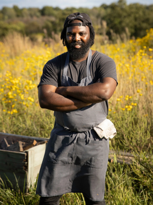 chef omar tate posing in a farm field