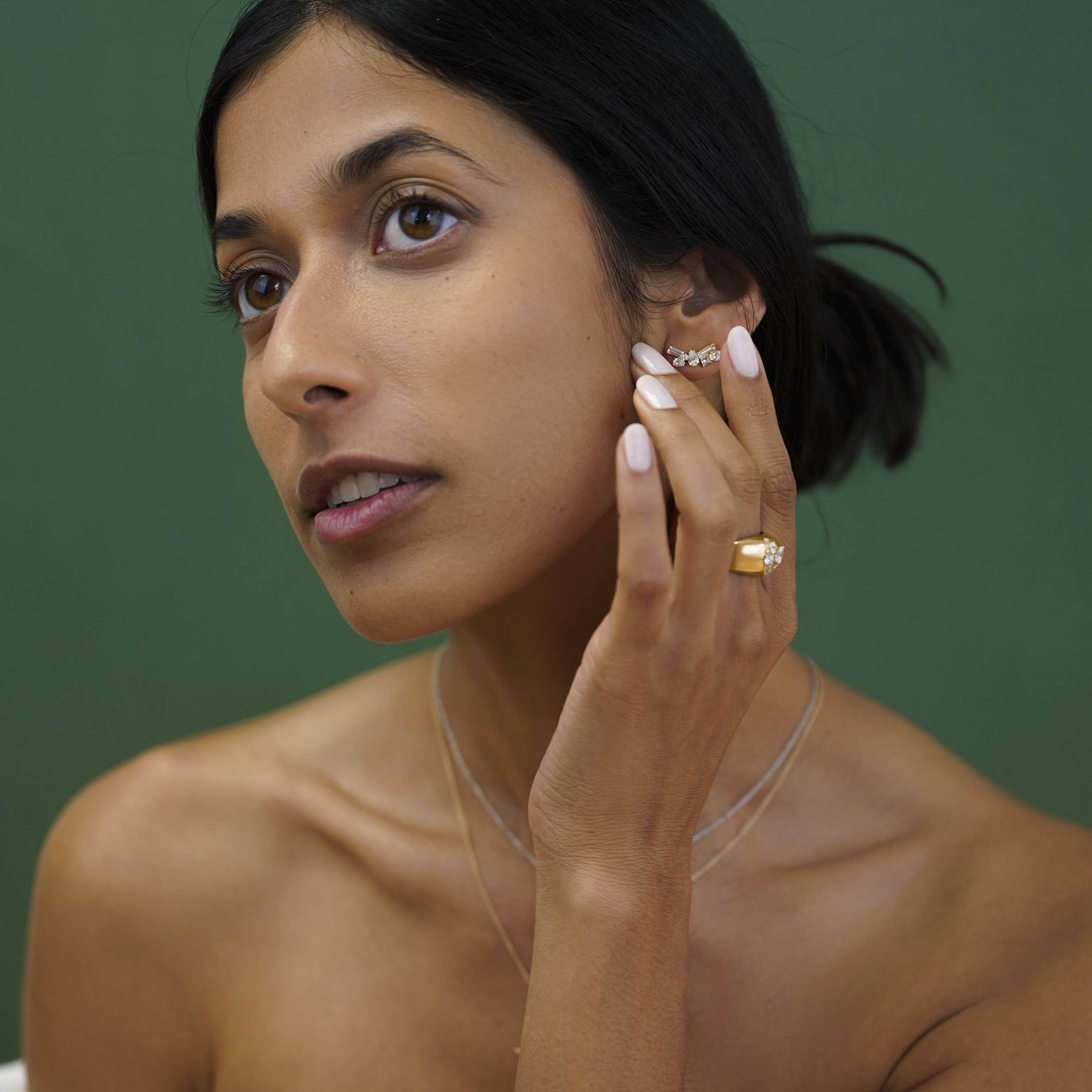 a woman models earrings and a ring by jewelry designer Dorian Webb