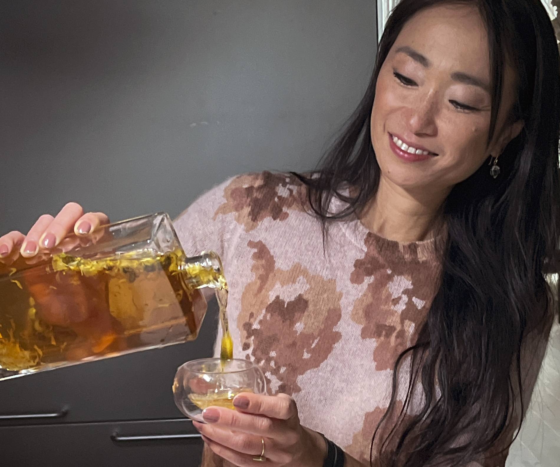 danielle chang pours herself some Chrysanthemum Elixir cocktail