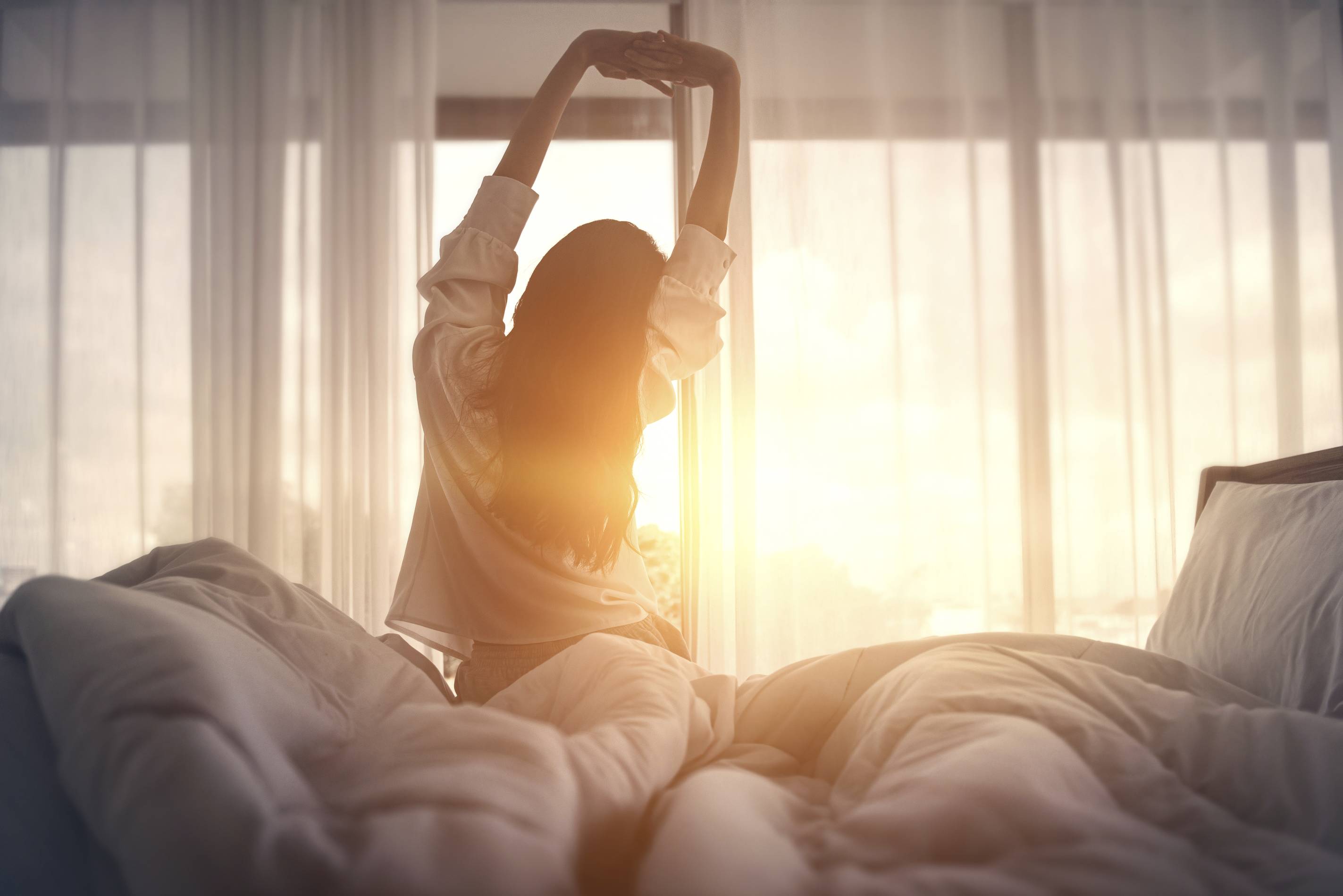 a woman stretches after waking up