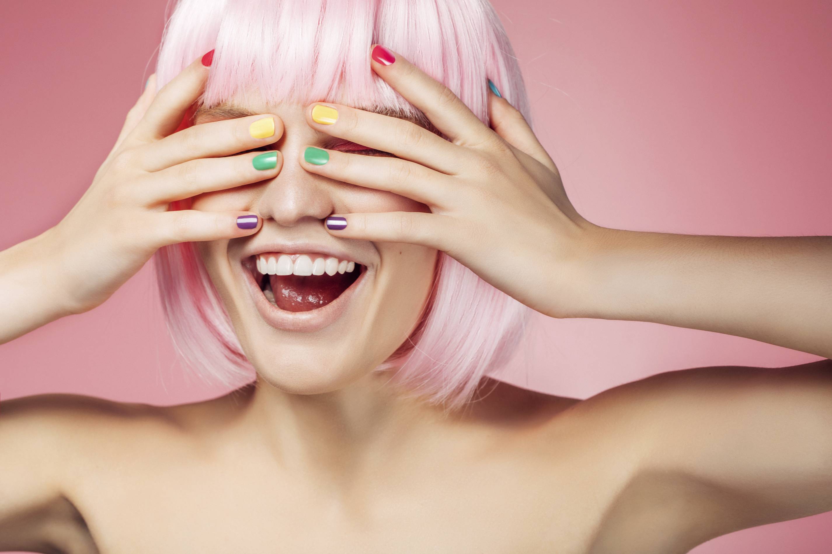 woman with pink hair and colorful nails