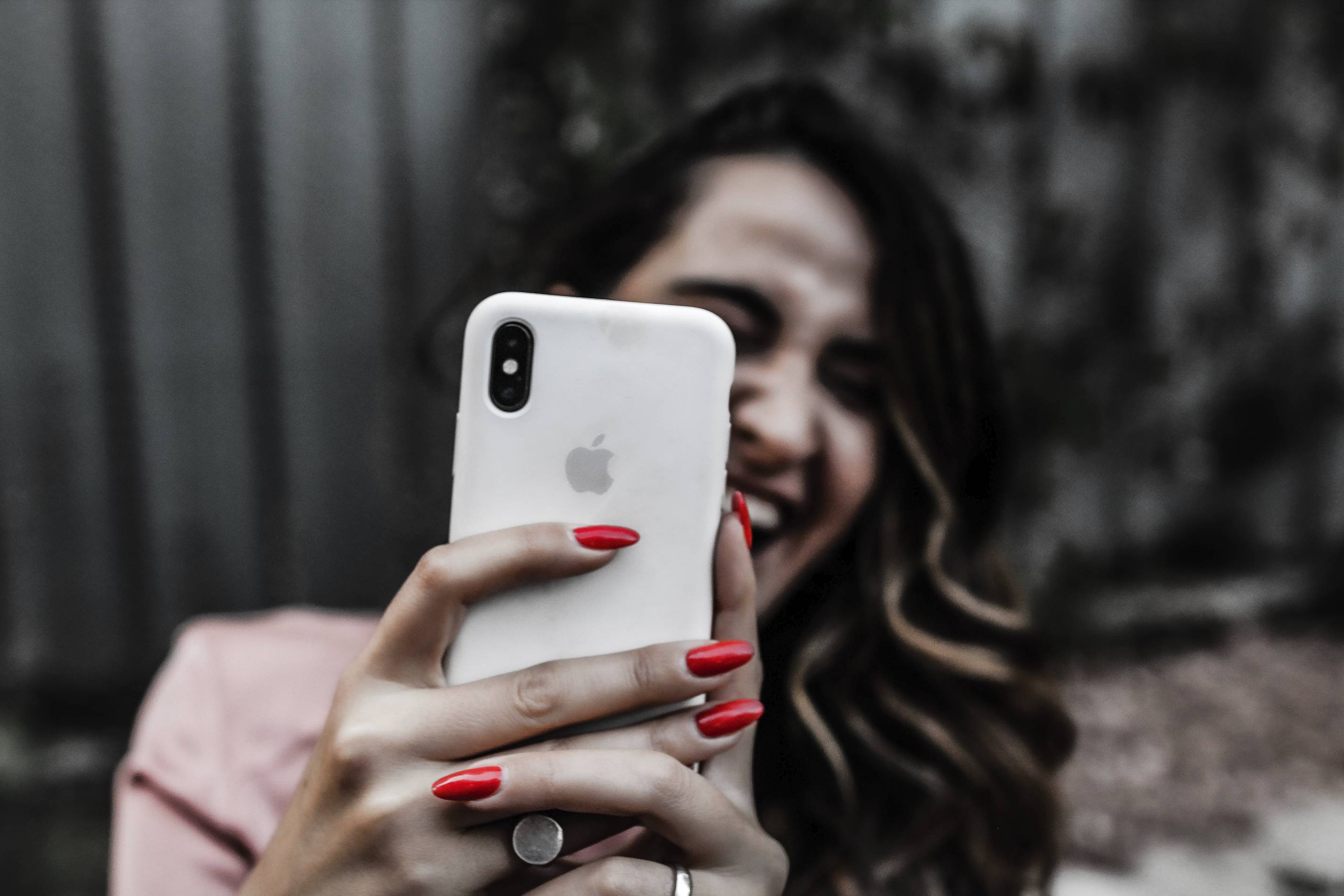 woman with red nails and an iPhone