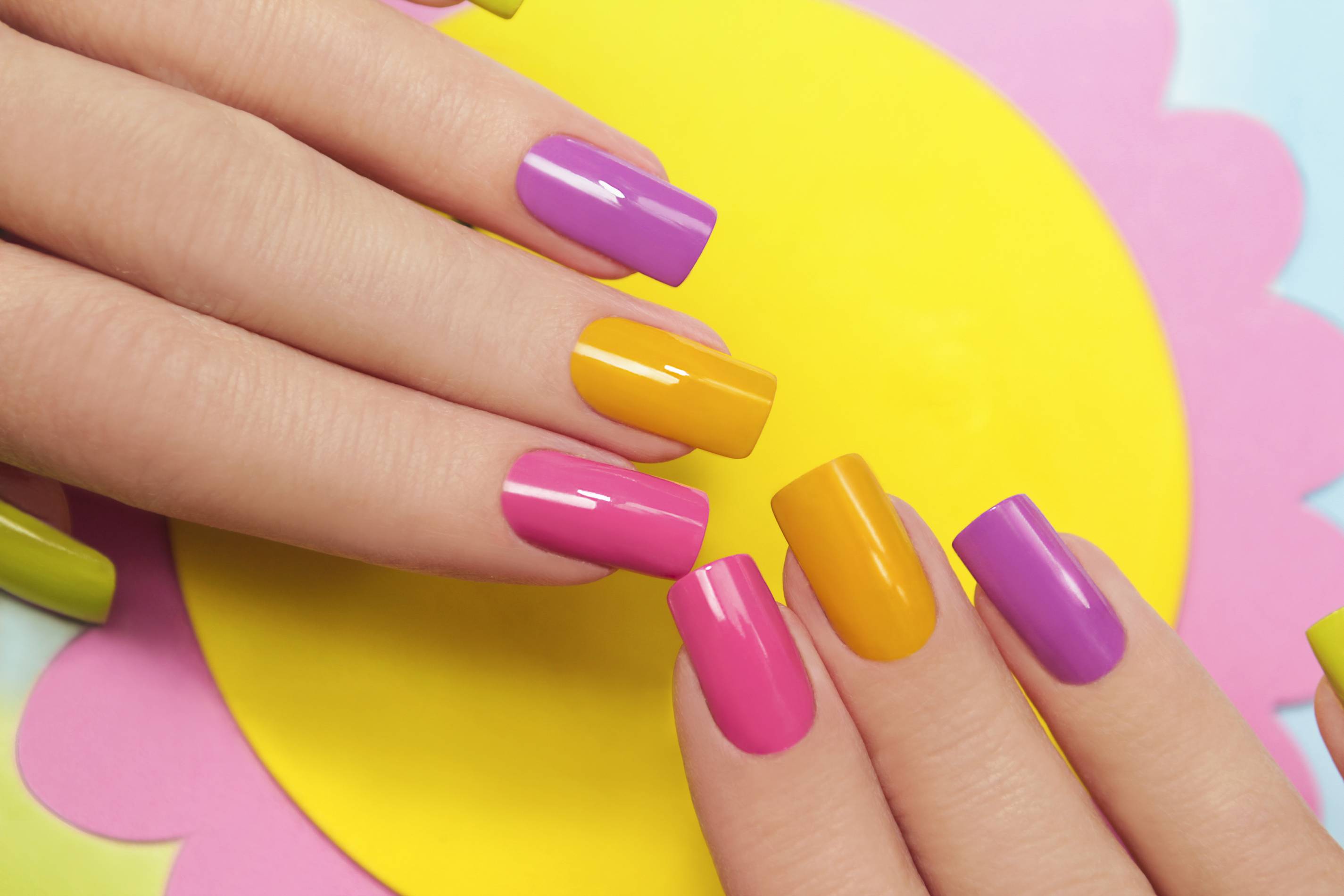 a woman models colorful nails